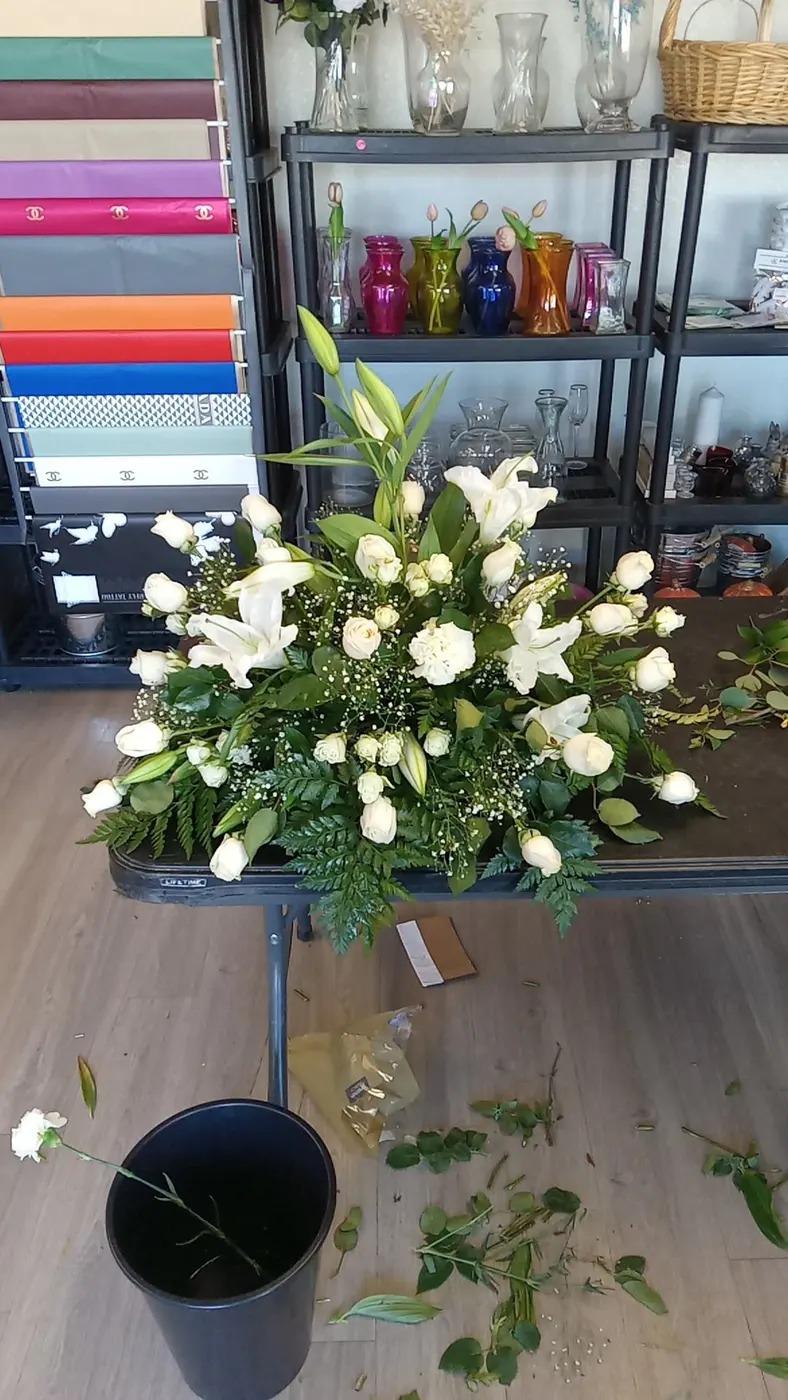 White rose and flower arrangement on a stand in the shop