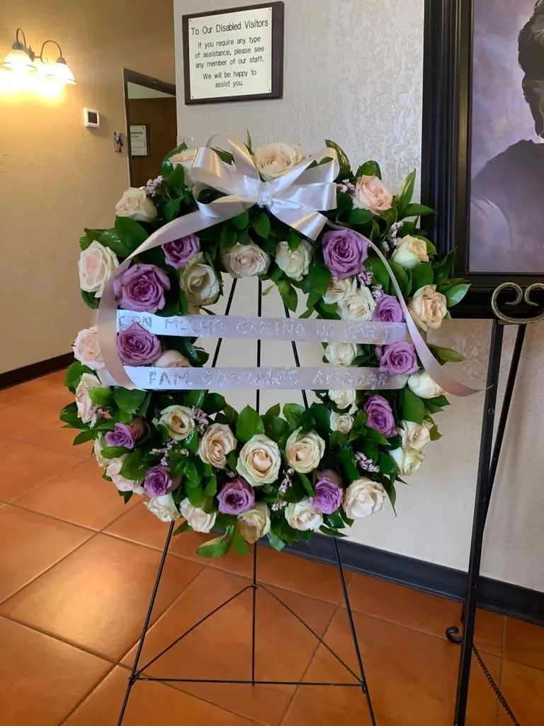 Purple and white rose wreath on an easel, sympathy arrangements Tucson